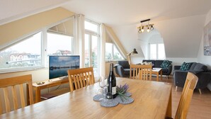 Un moderno apartamento tipo loft con comedor, sofá y televisor.