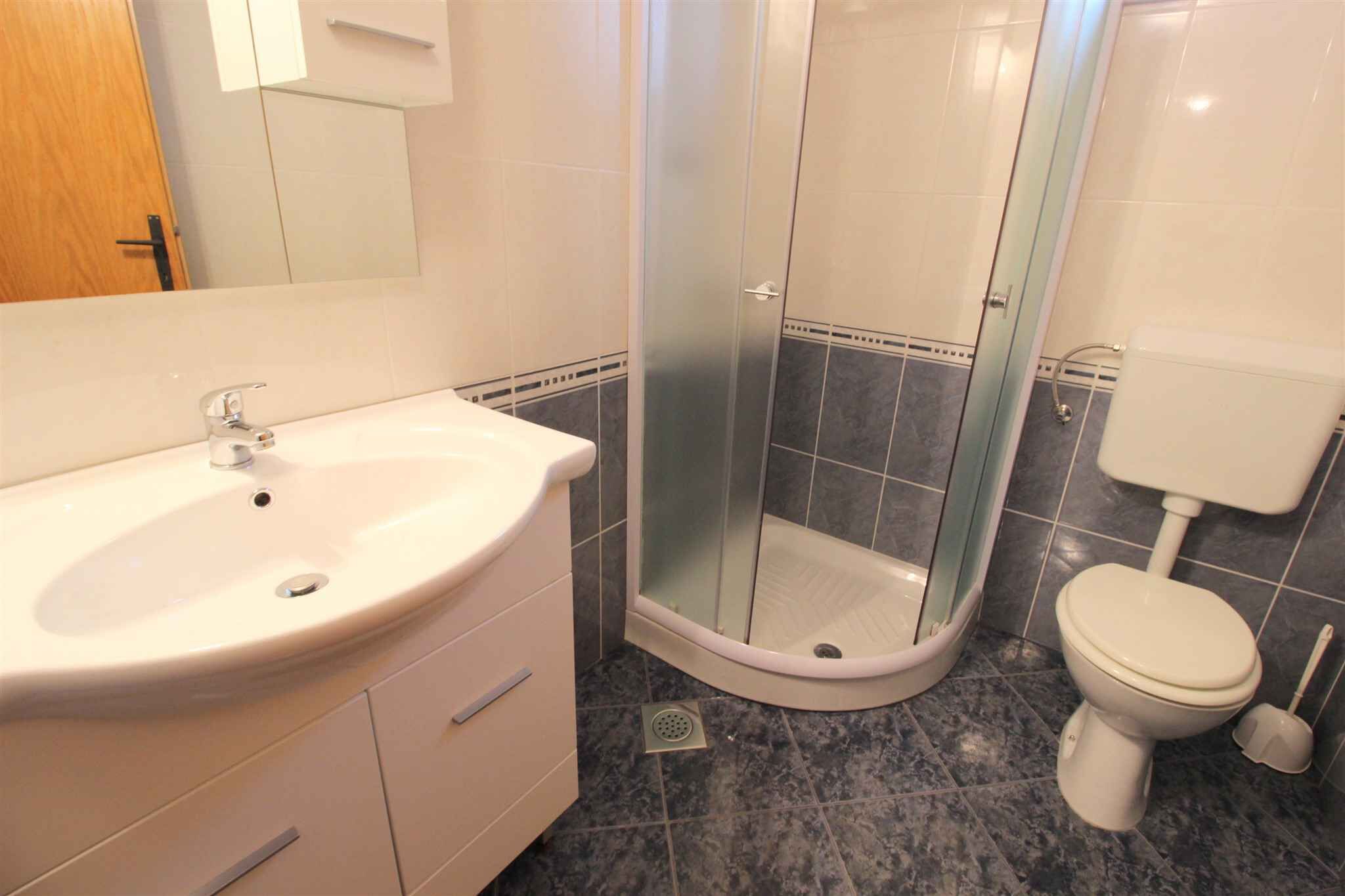 Un bagno con lavandino, servizi igienici e doccia vetrata.