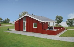 Een rood gebouw met een overdekte veranda en een raam.