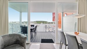 A balcony with a view of a marina and buildings, furnished with chairs and a table. - Priwallpromenade 23, Whg 7 (Travemünde Waterfront)