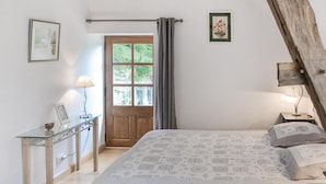A bedroom with a bed, a desk, a lamp, and a window with curtains. - Amazing home in Cravant les Côteaux (Cravant les Côteaux)