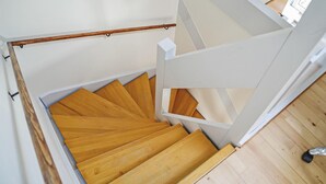 Una escalera de madera con barandas y pasamanos blancos.