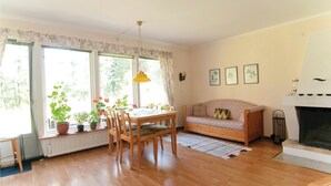 Ein gemütliches Wohnzimmer mit Holztisch, Sofa und Kamin.