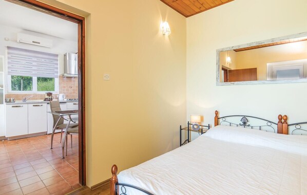 A bedroom with a bed, a bedside table, a mirror, and a view of the kitchen. - Cozy home in Trget with private swimming pool, can be inside or outside (Trget)
