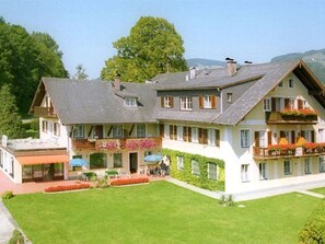 Un grand bâtiment à deux étages, doté d’un toit en pente, de nombreuses fenêtres et d’une pelouse bien entretenue.