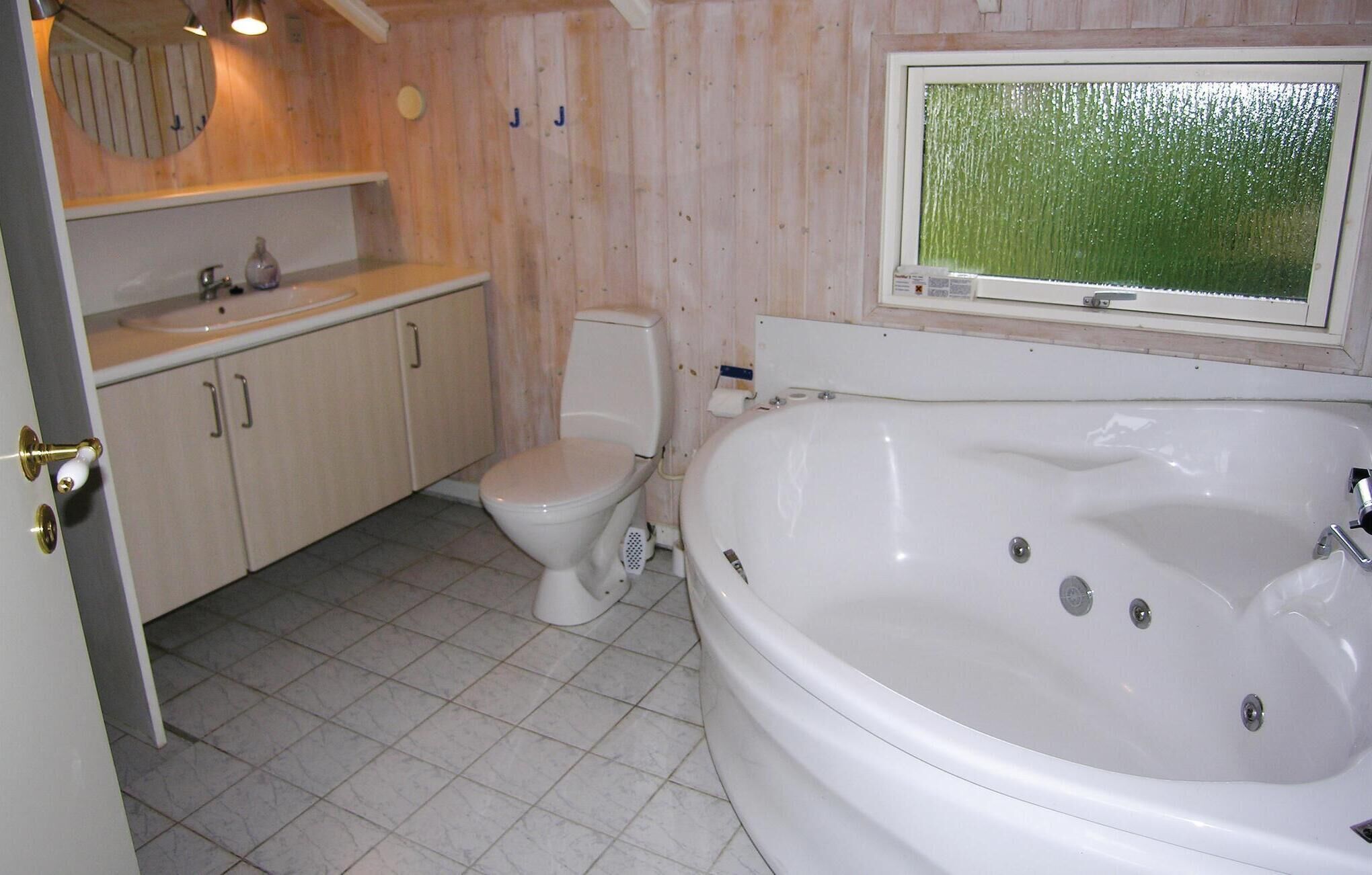 Un baño con bañera, inodoro y lavamanos.