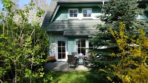 Ein zweistöckiges Haus mit einer Terrassenfläche.