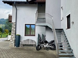 A modern building with a staircase, a bench, and a motorcycle parked outside.