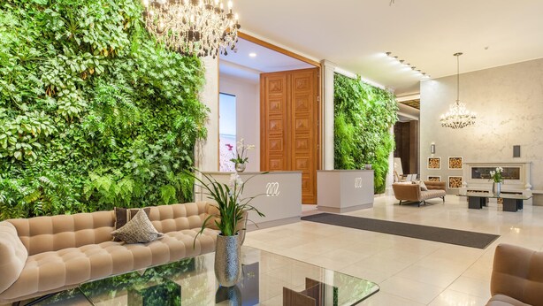 A modern lobby with a green wall, a glass coffee table, and a sofa. - Garden Suite Penthouse (Prora/Rügen)