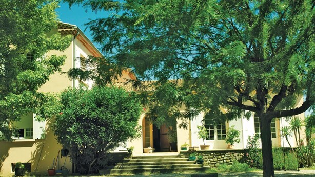 A two-story building with a stone staircase leading to a wooden door. - Lovely home in Montélimar (Montélimar)