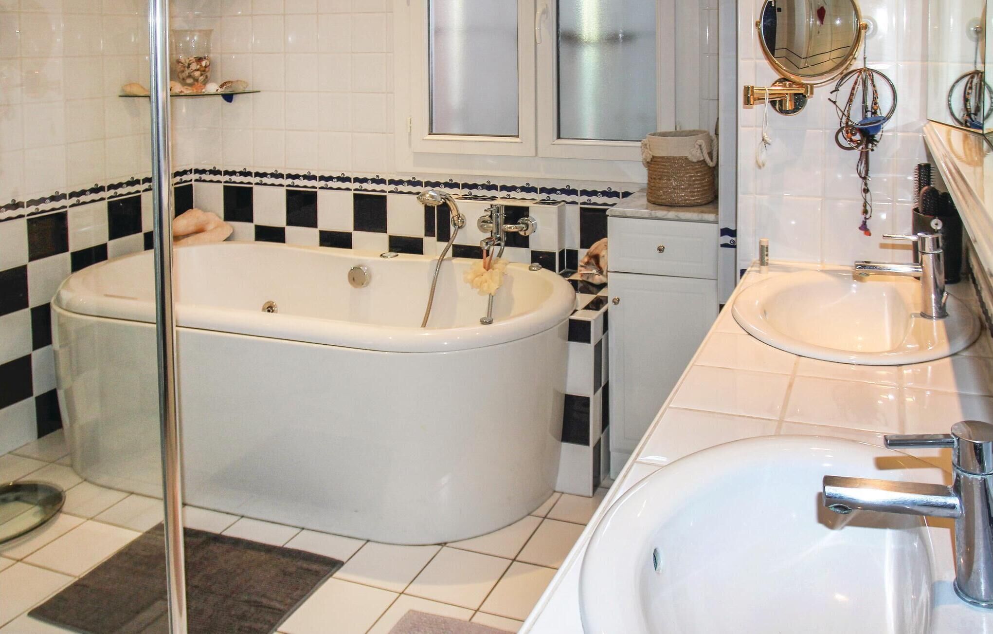 A bathroom with a bathtub, a sink, and a mirror.