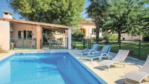 A swimming pool with lounge chairs and a covered patio area. - Lovely home in Montélimar (Montélimar)