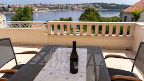 A terrace with a table set for two, overlooking a lake and a town. - 2 bedroom amazing apartment in Selca (Selca)