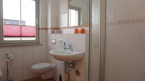 Un baño con inodoro, lavamanos y ventana.