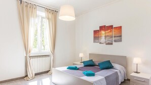 A bedroom with a bed, two bedside tables, a radiator, and a window with curtains. - Awesome home in Massa (MS) with WiFi (Massa (MS))