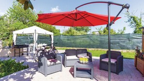 An outdoor patio with wicker furniture, a red umbrella, and a white tent. - Awesome home in Massa (MS) with WiFi (Massa (MS))