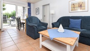 Een woonkamer met twee banken, een salontafel en een eetgedeelte met stoelen en een tafel.