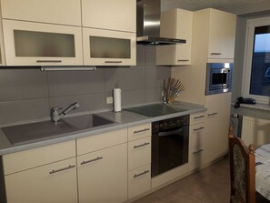 Kjøleskap, mikrobølgeovn, ovn og høy barnestol