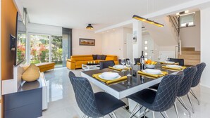 A modern dining area with a glass table, black chairs, and yellow placemats. - Stunning home in Malinska with sauna (Malinska)