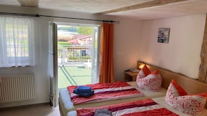 Une chambre d’hôtel avec un lit, une fenêtre avec des rideaux, un radiateur et une vue sur l’extérieur.