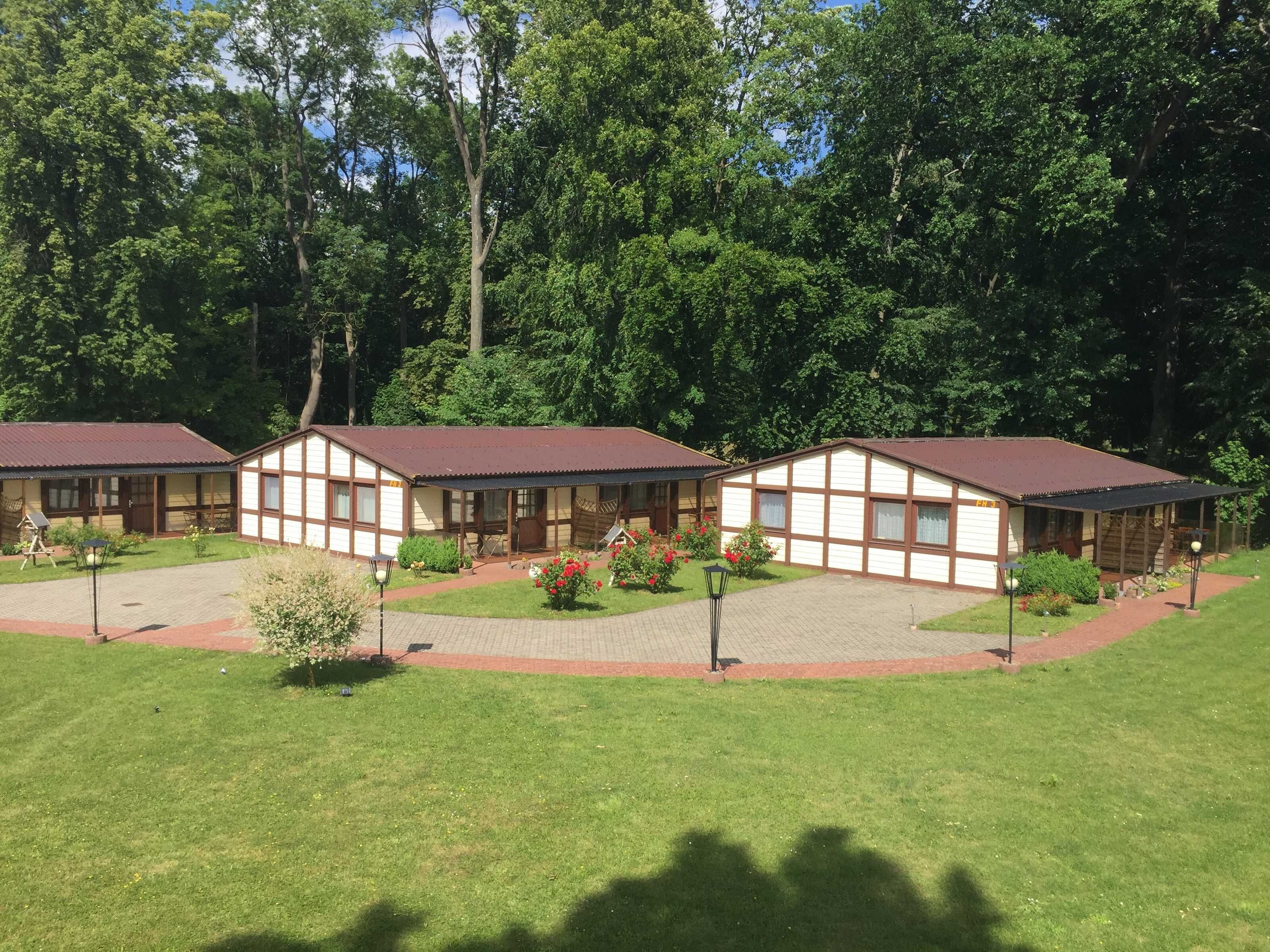 A row of two-story buildings with a central courtyard, surrounded by trees.