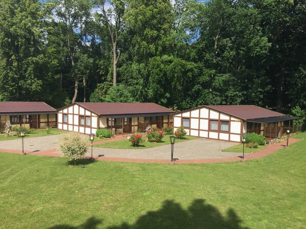 A row of two-story buildings with a central courtyard, surrounded by trees.