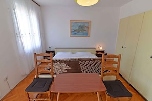 Ein Zimmer mit einem Bett, einem Gemälde, einem Schreibtisch und einem Stuhl.