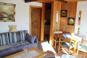 A cozy room with a sofa, a small table, and a dining area with chairs. - Vacation apartment Bianca - House Reese (Clausthal-Zellerfeld)