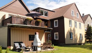 A two-story house with a balcony, outdoor seating, and a chimney. - Vacation apartment Bianca - House Reese (Clausthal-Zellerfeld)