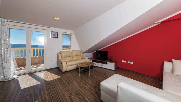 A modern living room with a sofa, a recliner, a coffee table, and a TV. - Holiday apartment with panoramic view (Dramalj)