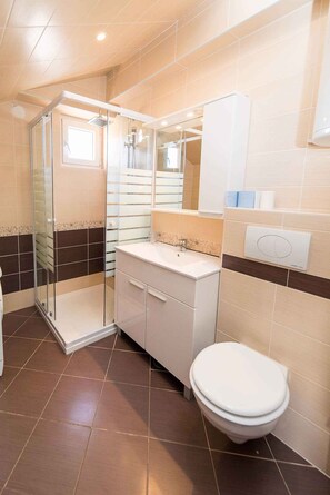A bathroom with a shower, toilet, and sink.
