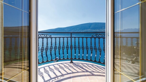 Un balcón con vistas al mar y a la montaña.