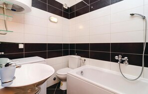Un baño con bañera, inodoro y lavabo.