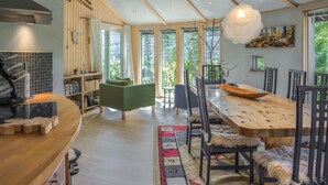 Een moderne keuken met houten kastjes, een inbouwfornuis en een eethoek met een houten tafel en stoelen.