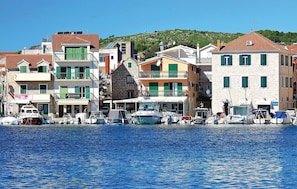 A coastal town with buildings along the waterfront, boats docked, and a clear blue sky. - 2 bedroom lovely apartment in Vodice (Vodice)