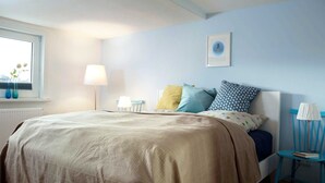A bedroom with a bed, bedside tables, a window, and a wall-mounted picture. - Haushimmelblau, Germany (Sankt Andreasberg)