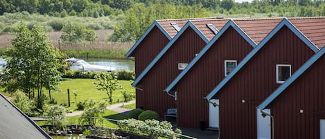A row of red buildings with a pond in front.