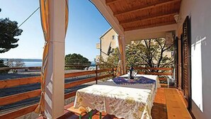 Un espacio al aire libre techado con mesa y sillas, con vista a un paisaje pintoresco.