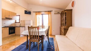 Un espacio habitable compacto con kitchenette, comedor y sofá.