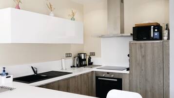 Fridge, stovetop, dishwasher, coffee/tea maker