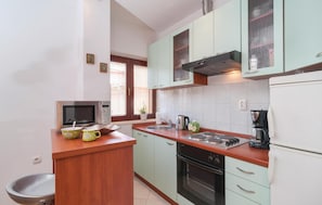 Enjoy cooking in this fully equipped kitchen with a central island, sink, stovetop, oven, and refrigerator.