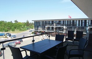 Enjoy the city view from this balcony with a table and chairs.