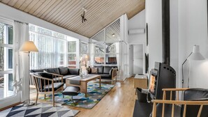 A spacious living room with a wooden ceiling, large windows, a fireplace, and modern furniture. - Gorgeous home in Hasle with WiFi (Hasle)