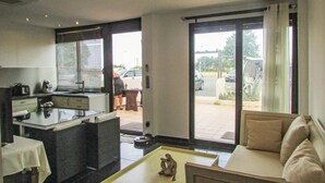 Een moderne keuken met een eethoek, een bank en uitzicht op de straat.