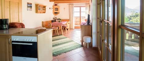 A kitchen with a Bosch oven, a dining area with a table and chairs, and a view through large windows.