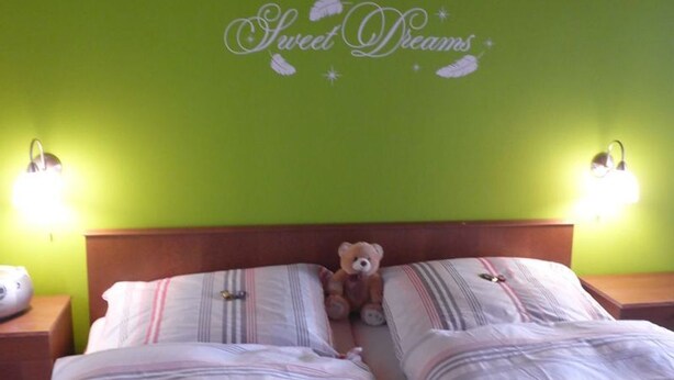 A room with two beds, a teddy bear on the left bed, and a wall with 'Sweet Dreams' written on it. - Double room 4 - Moadl farm (Miglberg)