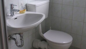 A bathroom with a white sink, toilet, and tiled walls. - Double room 4 - Moadl farm (Miglberg)