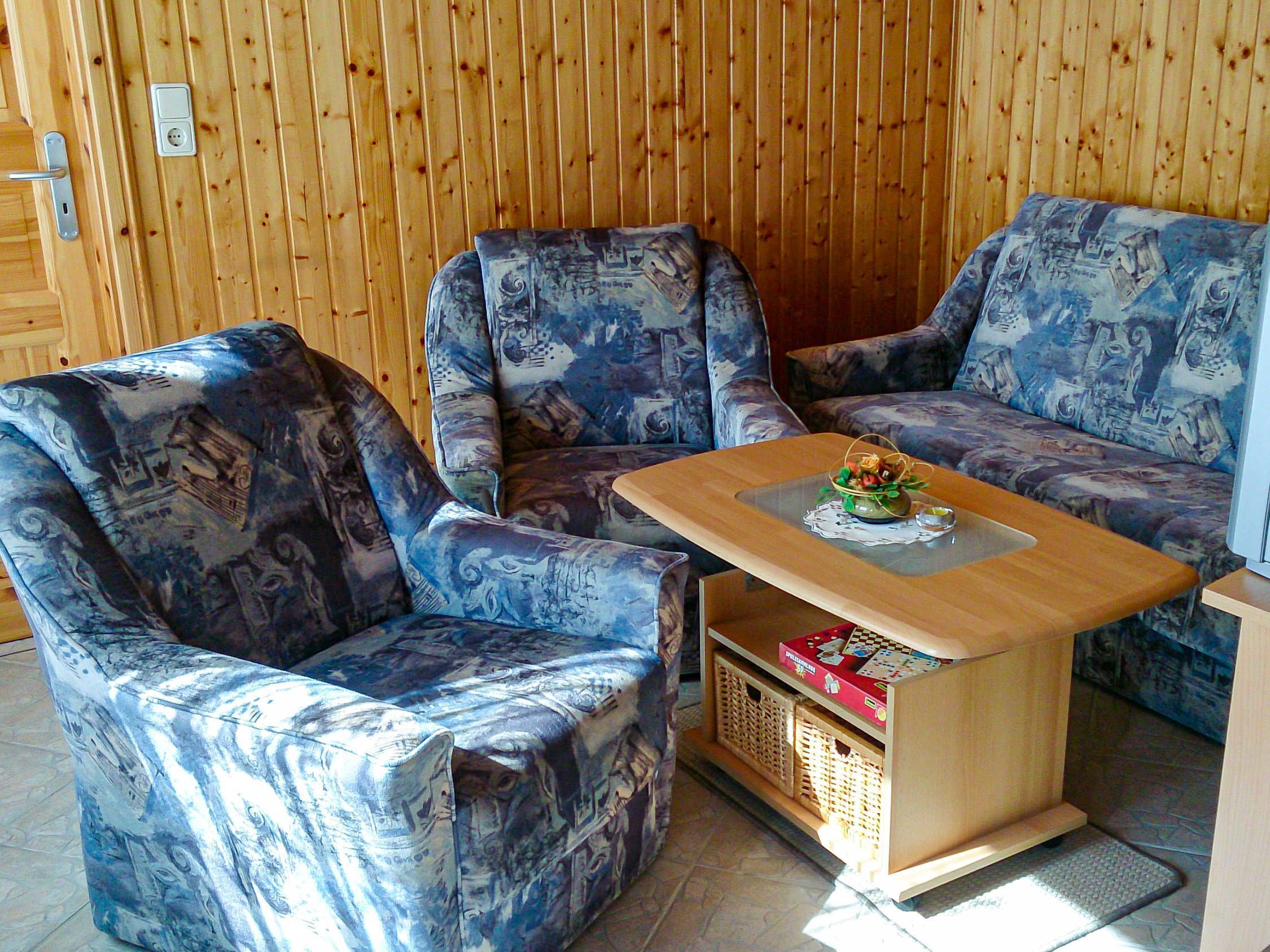 Ein Zimmer mit zwei gemusterten Sesseln und einem Holztisch mit einem dekorativen Gegenstand darauf.