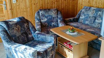 A room with two patterned armchairs and a wooden coffee table with a decorative item on it.