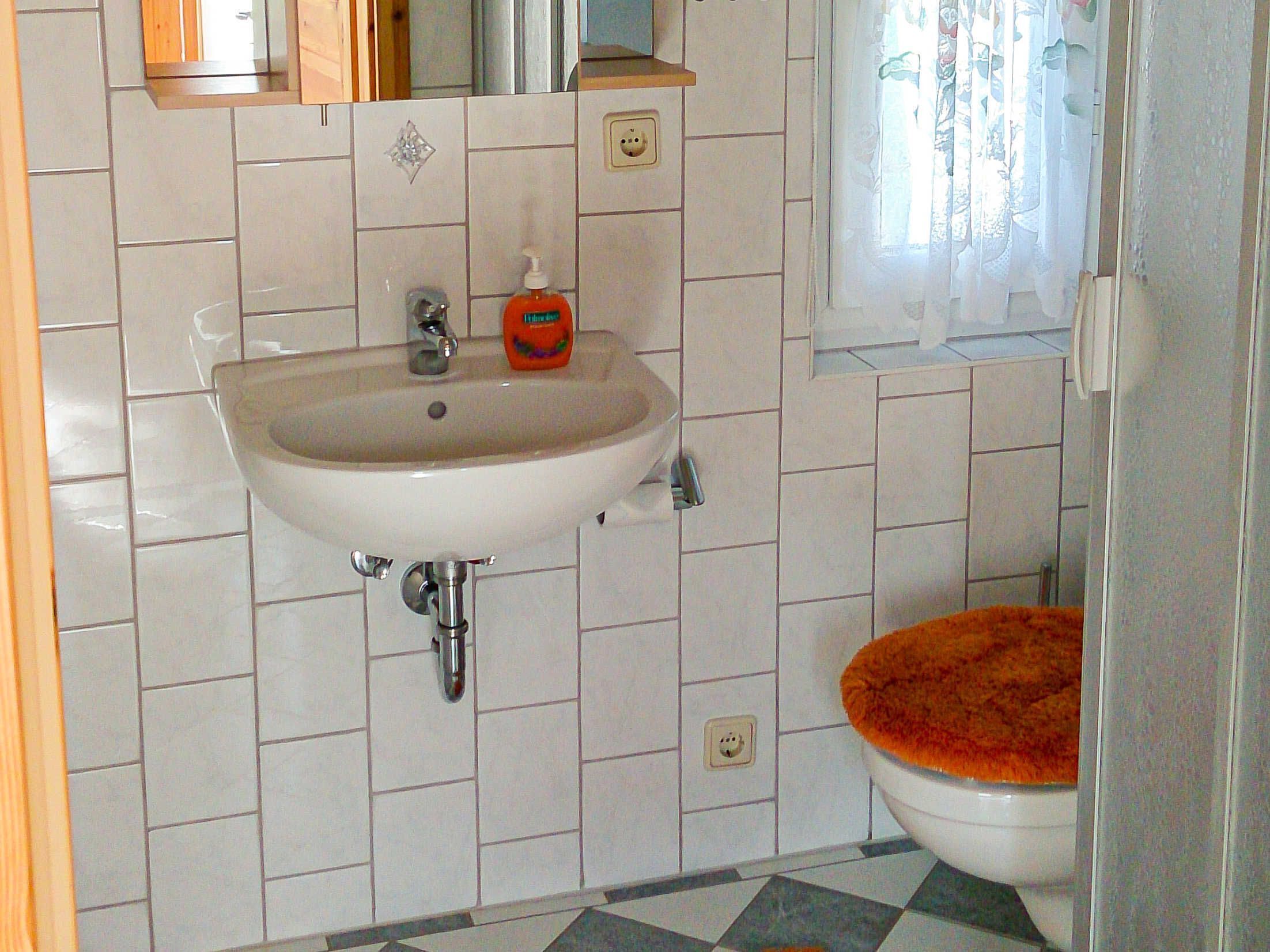 Ein Badezimmer mit Waschbecken, Toilette und Fliesen.